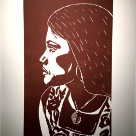 Linocut print in sepia color depicting a young woman's side profile.